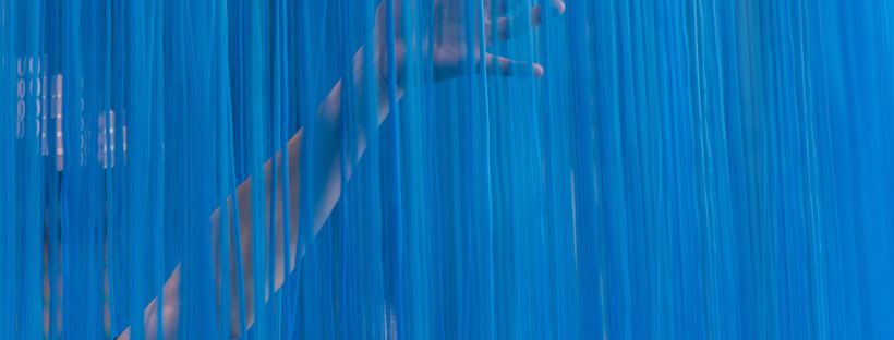 Person touching blue curtain
