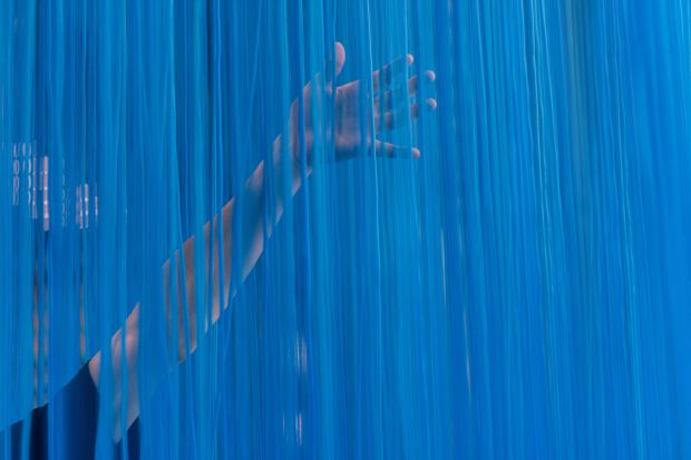 Person touching blue curtain