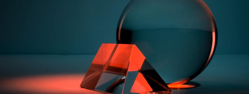 Photo of a see through sphere leaning against a triangular shape, the colour scheme blue and red