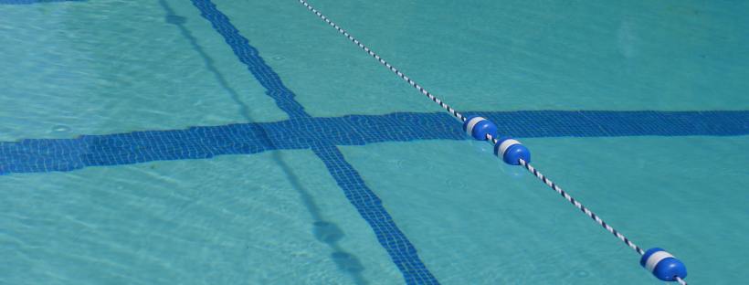 Photo of a blue chlorine swimming pool with blue lap lanes.