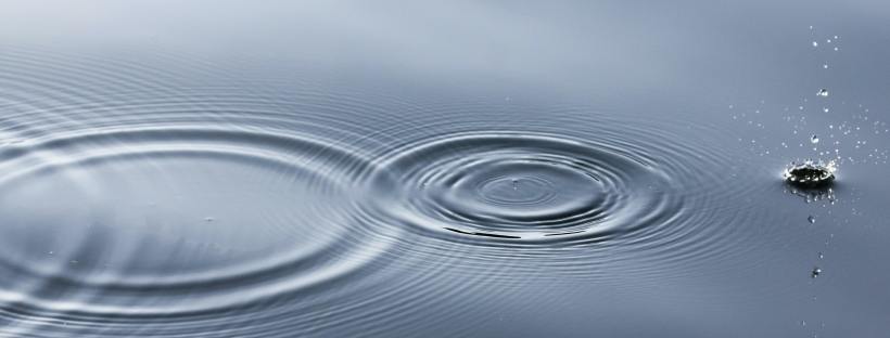 Photo of an object skipping across water and causing beautiful circle patterns.