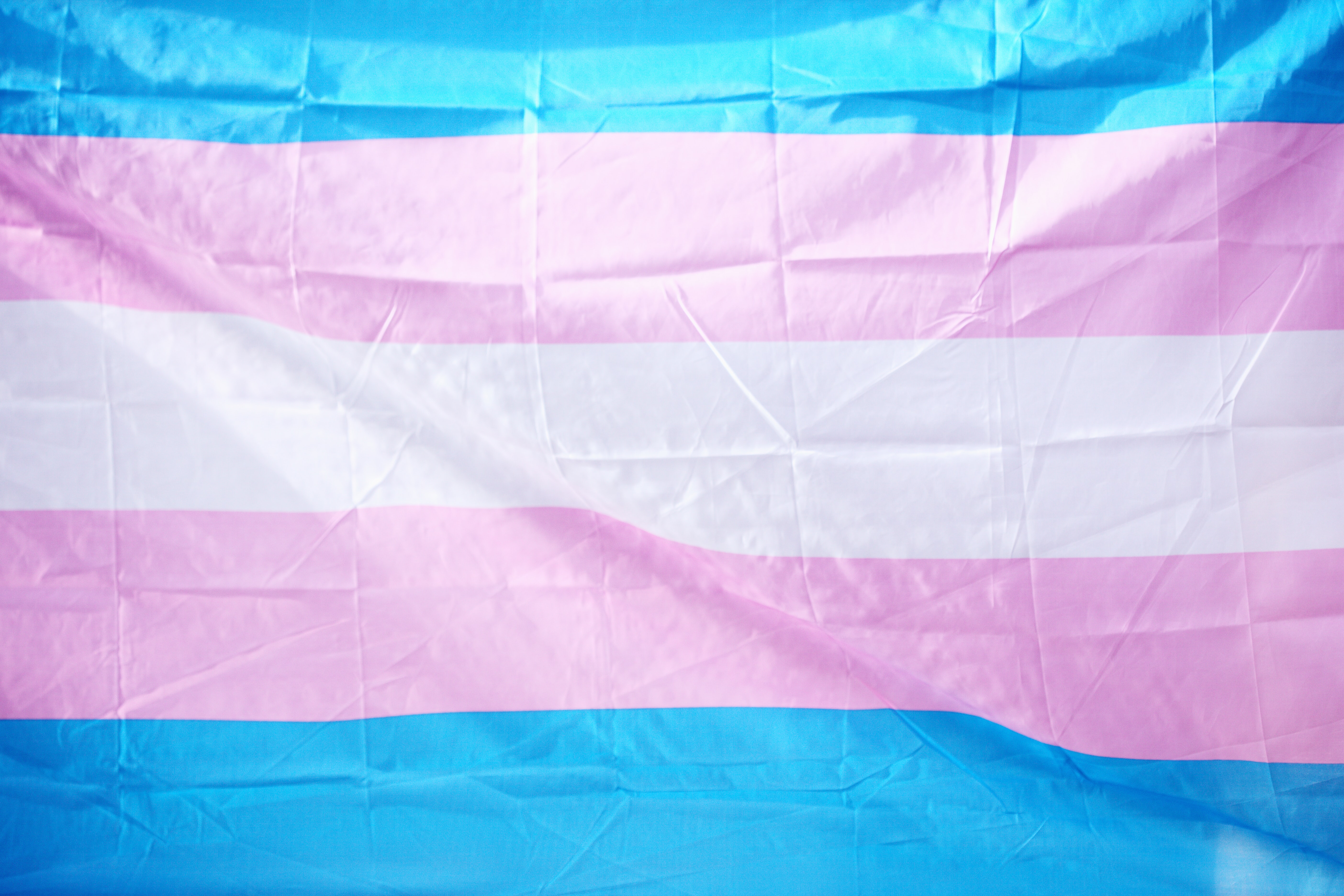 Photo of a slightly crumpled blue, pink and white transgender flag
