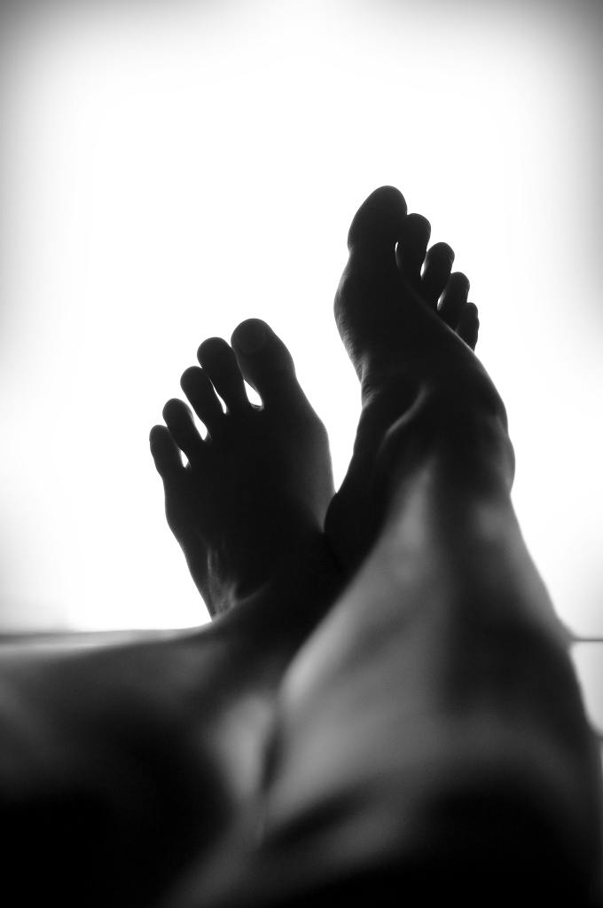 Black and white / monocrome photo of legs and feet with a white background