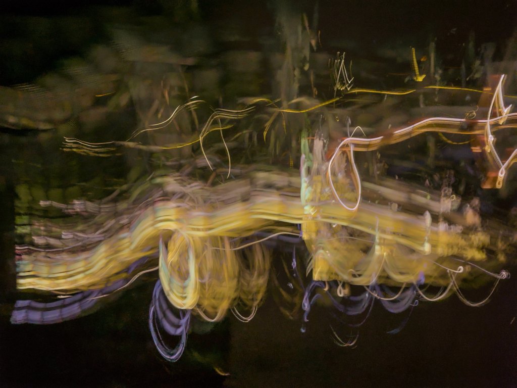 Textured photo of yellow and purple swirls on a dark coloured background.