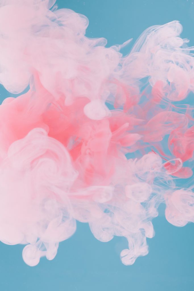 Abstract photo of pink coloured smoke on a blue background.