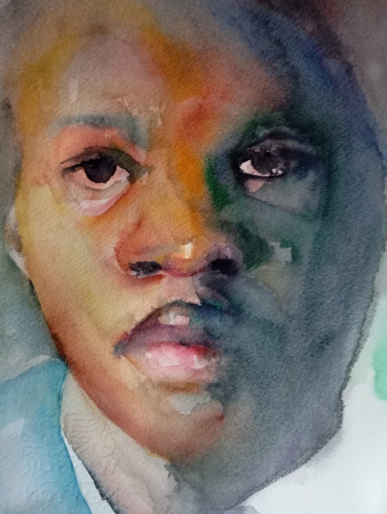 A watercolour painting of a young person with dark skin, shown from the shoulders up. The face is bathed in a spectrum of warm and cool colours - orange, green, and blue.